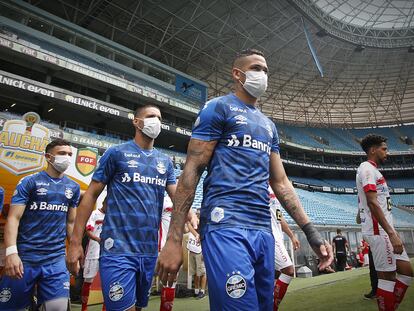 Jogadores do Grêmio entram em campo com máscaras como forma de protesto.