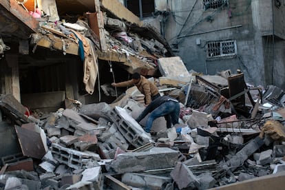 Palestinos buscan bajo los escombros a los miembros desaparecidos de su familia tras un ataque aéreo israelí en Jan Yunis, este domingo. 
