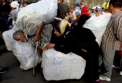 Para cruzar la aduana del paso fronterizo del Barrio Chino, los porteadores tienen que guardar una cola de unos 30 metros. Los propios paquetes sirven de apoyo para descansar tras la dura subida por la rampa desde las furgonetas.