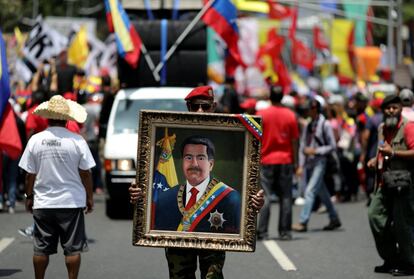 Un simpatizante del líder chavista Nicolás Maduro sostiene un cuadro con su retrato durante una manifestación en Caracas (Venezuela), el 20 de mayo de 2019. Maduro llamó a su electorado a reunirse en las calles para celebrar el aniversario de las elecciones presidenciales celebradas el 20 de mayo de 2018, en las que se proclamó vencedor en medio de una abstención récord y denuncias de fraude. Ese día, tras acudir a su colegio electoral, el mandatario había lanzado una advertencia a los venezolanos: “Votos o balas”.