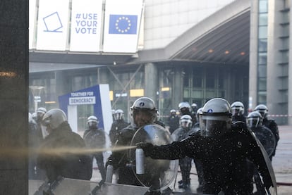 Un agente de policía utiliza gas pimienta durante la protesta de los agricultores frente al Parlamento Europeo, este jueves en Bruselas. 