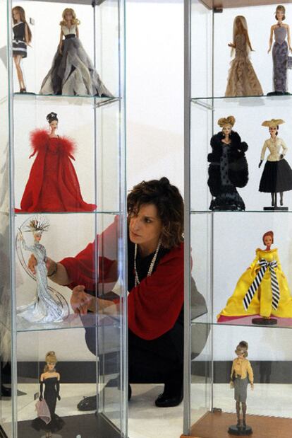La diseñadora Celina Martín coloca las muñecas en una vitrina.