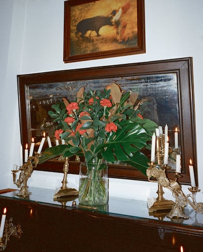 Los claveles y las pinturas aportan el toque casticista. Los muebles de madera oscura y los candelabros de latón, una sabia dosis de elegancia clásica.
