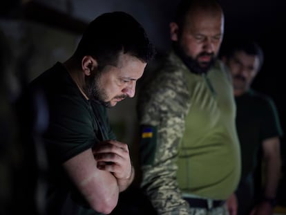 In this photo provided by the Ukrainian Presidential Press Office, Ukrainian President Volodymyr Zelenskyy, left, listens to a servicemen report close to the front line in Donetsk region, Ukraine, Sunday, June 5, 2022. (Ukrainian Presidential Press Office via AP)