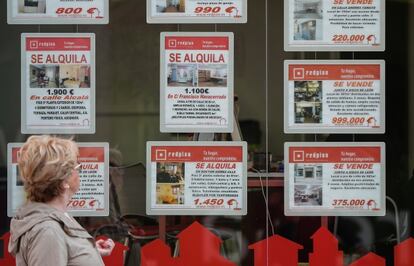 Una mujer mira el escaparate de una agencia inmobiliaria en Madrid.