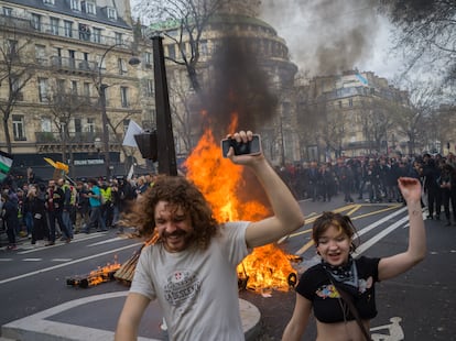 Manifestantes junto a una barricada que arde en una calle de París, el jueves.