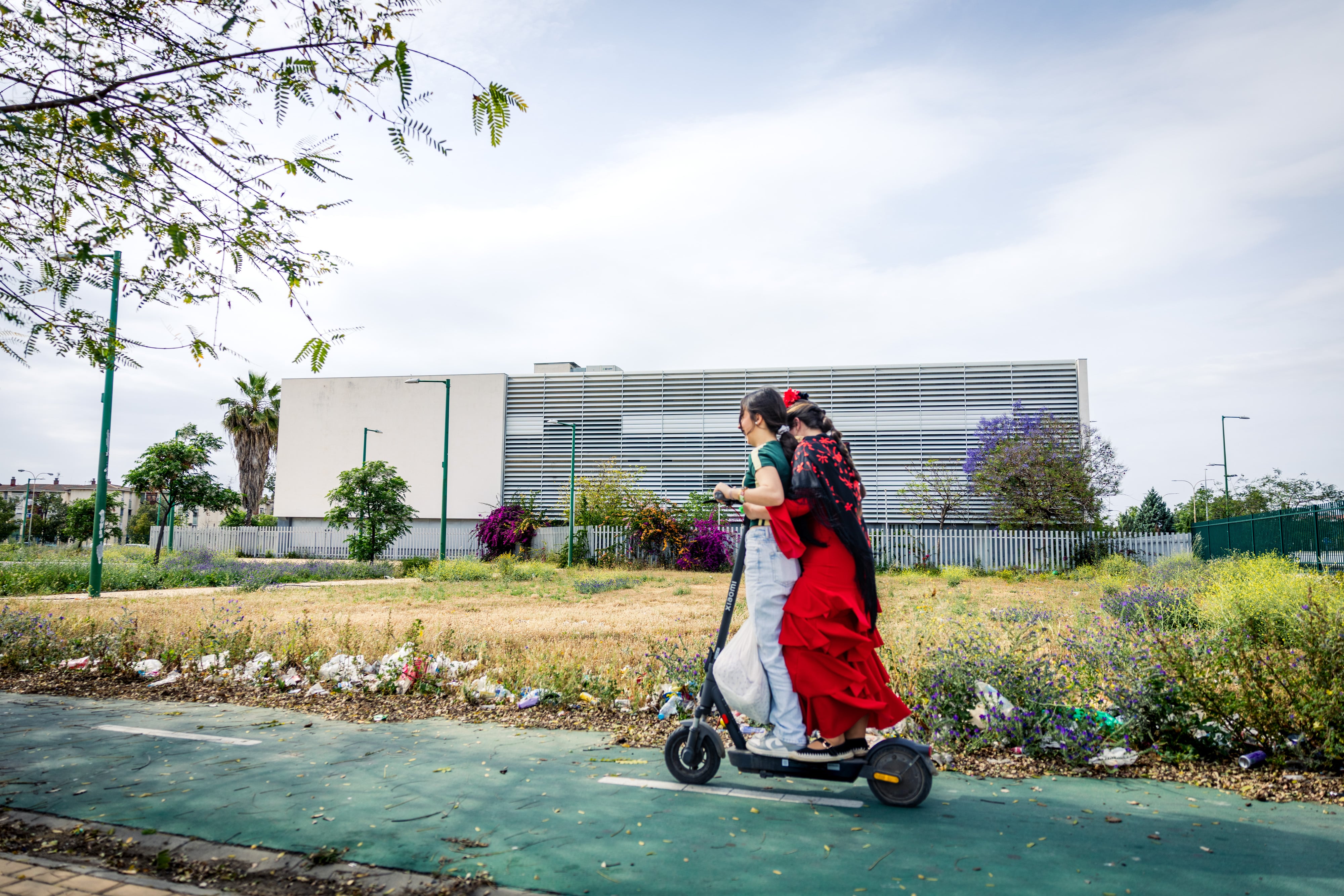 Dos jóvenes viajan en un patinete en la barriada de Las 3.000 Viviendas de Sevilla, el día 23 de abril.