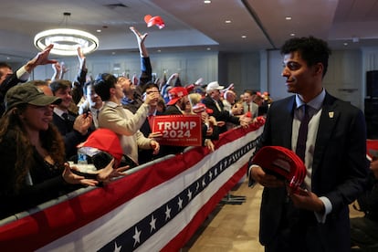 Personal del equipo de Trump reparte gorras entre sus seguidores en Nashua, New Hampshire.