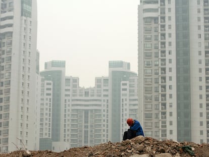 Un obrero de la construcción toma un descanso frente a unos rascacielos residenciales en Shanghái.