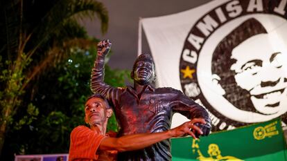 Un hombre toca una estatua de la leyenda Pelé en Santos (Brasil), el 29 de diciembre.
