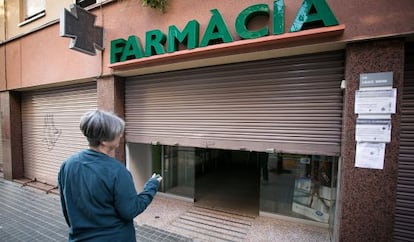 Una farmàcia amb la persiana baixada en senyal de protesta.