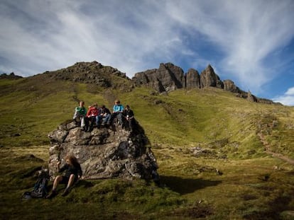 Estudiantes en una excursi&oacute;n al cerro rocoso de Old Man of Storr, que se ve al fondo, en la isla de Skye (Escocia). 