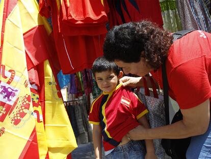 Una madre compra una camiseta con los colores de España a su hijo.