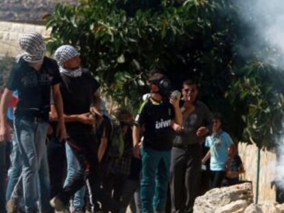 Un palestino devuelve un bote de humo lanzado por el Ej&eacute;rcito en una protesta contra la ocupaci&oacute;n de terrenos cerca de Nablus, en Cisjordania.