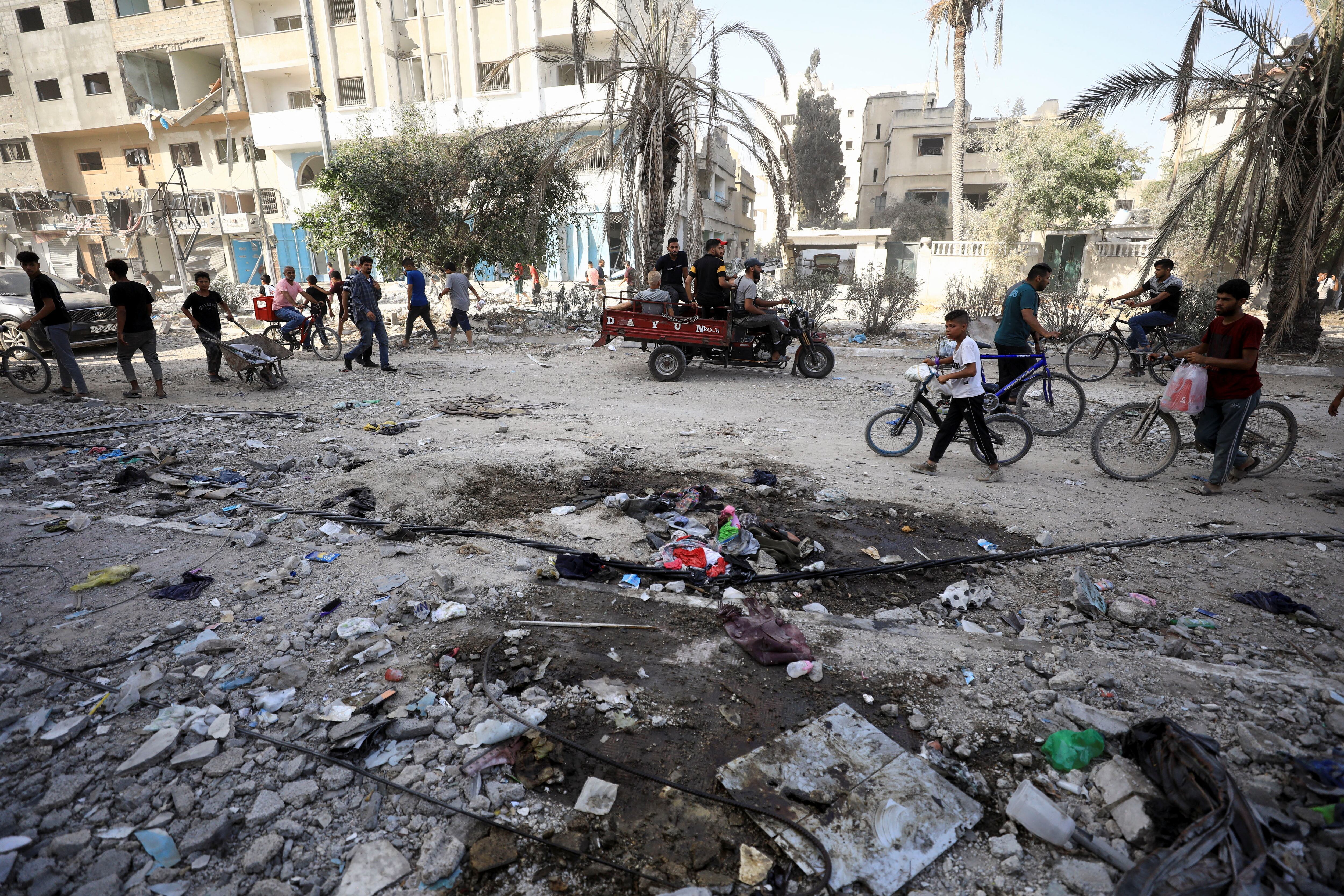 Palestinians pass by the damages, after Israeli forces withdrew from a part of Gaza City, following a ground operation, amid the Israel-Hamas conflict, in Gaza City, July 12, 2024. REUTERS/Dawoud Abu Alkas