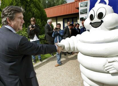El consejero de Industria, Bernabé Unda, saluda a Bibendum, el muñeco emblemático de Michelin, al llegar a la factoría de Vitoria.