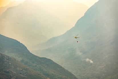Un helicóptero lanza agua sobre el Teixadal de Casaio, en Ourense, este martes.