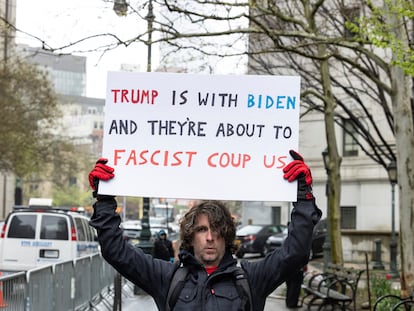 Max Azzarello, de St. Augustine (Florida), la víspera de prenderse fuego el viernes frente al tribunal de Nueva York donde se celebraba el juicio contra Donald Trump. "Trump está con Biden y están a punto de darnos un golpe fascista", dice su pancarta.