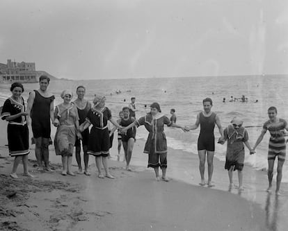 Un grupo de hombres y mujeres en la playa de Arenys de Mar, alrededor de 1920. / Arxiu Fotogràfic Centre Excursionista de Catalunya.