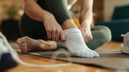 Una mujer poniéndose los calcetines.