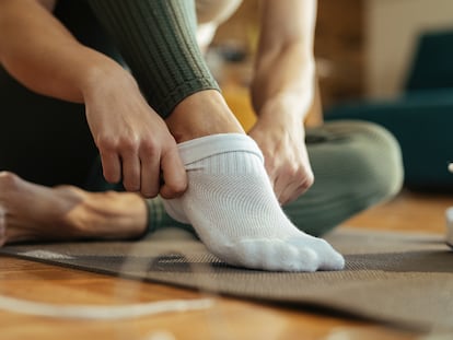Una mujer poniéndose los calcetines.