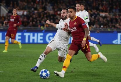 El defensa del Real Madrid, Dani Carvajal, y el jugador de la Roma, Justin Kluivert, luchan por hacerse con la posesión del balón en una acción del partido.