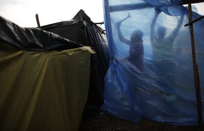 Desde el pasado sábado, más de 2.000 familias acampan en un terreno situado en la zona este de Sao Paulo desde donde se puede contemplar, a unos 4 kilómetros de distancia, el estadio que recibirá el partido inaugural del Mundial de fútbol el próximo 12 de junio. En la imagen, personas sin hogar trabajan en el campamento.