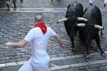 Un mozo corre ante los astados, durante del séptimo encierro de los sanfermines.