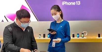 Una empleada de Apple atiende a un cliente en una tienda de la compañía en China.