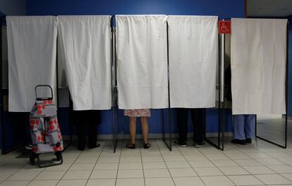 Varias personas preparan su voto en un colegio electoral en Vaulx-en-Velin (Francia).