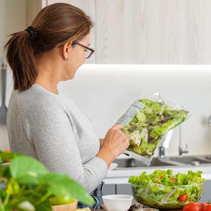 Woman reading nutrition label of a plastic packaged salad