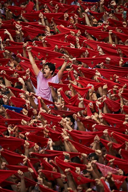 Un joven levanta un pañuelo rojo sobre la multitud durante el Chupinazo de este año. Los Sanfermines volvieron a las calles de Pamplona tras dos años sin celebrarse por la pandemia. 

