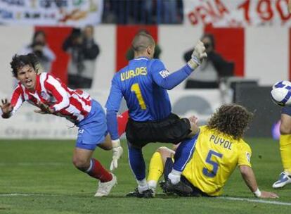 Agüero cae dentro del área del Barça ante Valdés, Puyol y Márquez.