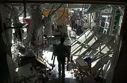 Un trabajador saca el mobiliario no dañado de un restaurante que fue bombardeado por el Ejército israelí en Belén, Cisjordania.