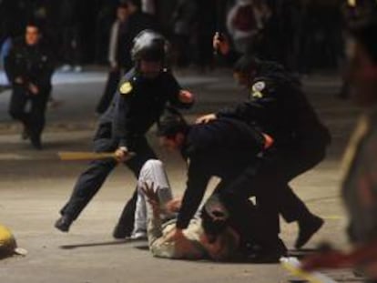 Fotografía cedida por la Agencia Telam que muestra
a dos policías enfrentados con manifestantes durante los incidentes que se registraron a las puertas de unas de las principales terminales ferroviarias de Buenos Aires (Argentina). EFE/Archivo