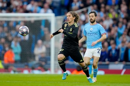 Luka Modric corre tras el balón perseguido por Bernardo Silva. 