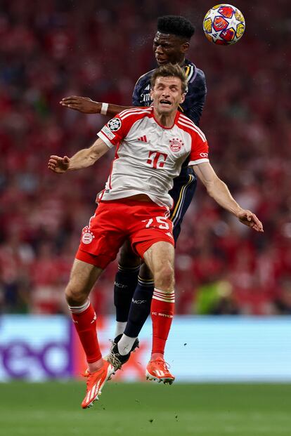 Thomas Mueller salta por un balón con un contrario