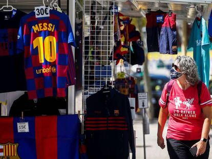 Una persona mirant una samarreta de Leo Messi en una parada prop del Camp Nou.