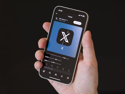 The X (formerly Twitter) logo is displayed on a cell phone.