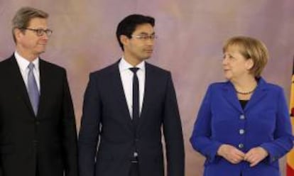 La canciller Alemana Angela Merkel (d), el ministro alemán de Economía, Philipp Rösler (c), y el ministro alemán de Exteriores, Guido Westerwelle (i), ayer en el acto en el que el presidente alemán, Joachim Gauck (no aparece), despidió a los integrantes del Gobierno germano, que desde ayer trabajan en funciones hasta la constitución de un nuevo Ejecutivo, en el Palacio de Bellevue en Berlín (Alemania).