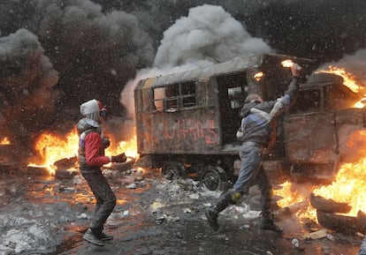 Dos manifestantes lanzan cócteles molotov a la policía, durante los enfrentamientos.