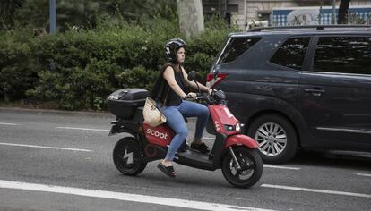 Una usuaria con una moto eléctrica de alquiler.