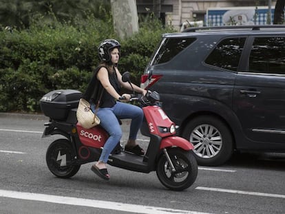 Una usuaria con una moto eléctrica de alquiler.