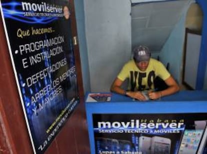 Un cuentapropista técnico en reparación de celulares espera la llegada de clientes a su local, en La Habana (Cuba).