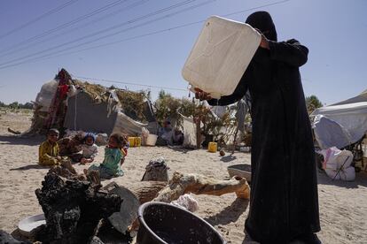 Una mujer vierte las últimas gotas de agua de una botella para preparar la comida junto a su tienda de campaña en el campo de Al-Khuseif para desplazados internos en Marib, Yemen. La familia trae agua potable en botellas de lejos porque no hay en la zona. Pincha en la imagen para ver la fotogalería completa.