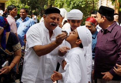 Un hombre ofrece un dulce a un niño durante la celebración del Nuevo Año Parsi en Alhmedabad (India).