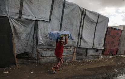 Una desplazada palestina carga con tortas de pan en Deir el Balah, en el sur de Gaza.