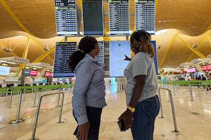 Dos viajeras consultan el panel de salidas de los vuelos en la zona de facturación de la Terminal 4 del Aeropuerto Adolfo Suárez Madrid-Barajas, a 1 de agosto de 2023, en Madrid (España).