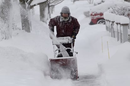 Um homem tira a neve em uma periferia de Chicago.