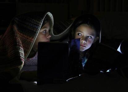 Dos niñas leen un cuento antes de ir a dormir.